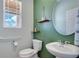 Compact powder room featuring a pedestal sink, floating shelves, and a decorative mirror at 9426 Launch Point Rd, Orlando, FL 32832