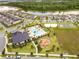 Aerial view of the community showing the pool, playground, sports court, and surrounding homes near the lake at 9846 Palmetto Dunes Ct, Orlando, FL 32832