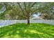 Beautiful backyard featuring a lush green lawn, mature trees, and a white picket fence at 9846 Palmetto Dunes Ct, Orlando, FL 32832