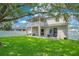 Expansive backyard with green lawn, white fence, patio, and a covered balcony at 9846 Palmetto Dunes Ct, Orlando, FL 32832