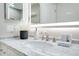 A bathroom vanity with a marble top, brushed nickel faucet, and illuminated mirror at 9846 Palmetto Dunes Ct, Orlando, FL 32832