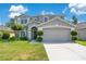 Charming two-story home featuring a well-manicured lawn and an attached two-car garage at 9846 Palmetto Dunes Ct, Orlando, FL 32832