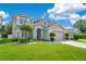 Beautiful two-story home with a well-manicured lawn, mature landscaping, and neutral color palette at 9846 Palmetto Dunes Ct, Orlando, FL 32832