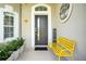 Welcoming front porch with a modern door, stylish decor, and a bright yellow bench at 9846 Palmetto Dunes Ct, Orlando, FL 32832