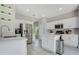 Bright kitchen features stainless steel appliances, white cabinetry, quartz countertops, and a kitchen island at 9846 Palmetto Dunes Ct, Orlando, FL 32832