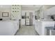 Bright kitchen features stainless steel appliances, white cabinetry, quartz countertops, and decorative floating shelves at 9846 Palmetto Dunes Ct, Orlando, FL 32832