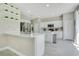 Bright kitchen features stainless steel appliances, white cabinetry, quartz countertops, and decorative floating shelves at 9846 Palmetto Dunes Ct, Orlando, FL 32832