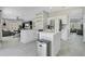 Open concept kitchen features stainless steel appliances, white cabinetry, quartz countertops, and a kitchen island at 9846 Palmetto Dunes Ct, Orlando, FL 32832
