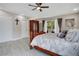 This bedroom with light gray plank floors has a balcony and an armoire at 9846 Palmetto Dunes Ct, Orlando, FL 32832