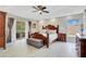 Spacious main bedroom with wood floors, a sitting bench and a private balcony at 9846 Palmetto Dunes Ct, Orlando, FL 32832