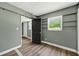 This bedroom features wood-look floors, a built-in bookshelf, and a window providing natural light at 1257 N Pine Hills Rd, Orlando, FL 32808