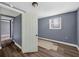 View of a bedroom with a door, wood laminate floors, and neutral gray paint at 1257 N Pine Hills Rd, Orlando, FL 32808