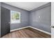Bedroom with a window, gray walls, new vinyl flooring, and modern gray door at 1257 N Pine Hills Rd, Orlando, FL 32808
