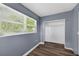 Bedroom featuring a window, closet, wood laminate floors, and neutral gray paint at 1257 N Pine Hills Rd, Orlando, FL 32808