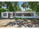 The house's exterior has nice architectural details and is surrounded by large trees, providing shade at 1257 N Pine Hills Rd, Orlando, FL 32808