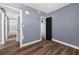 Hallway featuring gray walls and wood-look vinyl floors, leading to bedrooms at 1257 N Pine Hills Rd, Orlando, FL 32808