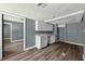Simple kitchenette area with white cabinets, hardwood floors, and a view to the living room at 1257 N Pine Hills Rd, Orlando, FL 32808