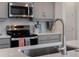 Modern kitchen sink and faucet with gray cabinets and stainless appliances at 1388 Lombardi Ct, Kissimmee, FL 34759