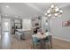 Well-lit kitchen with a large island, modern appliances, stylish dining set, and a contemporary chandelier at 1388 Lombardi Ct, Kissimmee, FL 34759