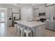 Modern kitchen features gray cabinets, stainless steel appliances, a spacious island with white countertop, and stylish stools at 1388 Lombardi Ct, Kissimmee, FL 34759