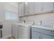 Functional laundry room with washer, dryer, storage cabinets, and a sink for added convenience at 1388 Lombardi Ct, Kissimmee, FL 34759