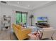 Bright living room with modern furniture, a large window showcasing a lush outdoor view, and stylish decor at 1388 Lombardi Ct, Kissimmee, FL 34759