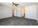 Carpeted bedroom with ceiling fan, neutral walls, and two access doors providing convenience at 148 Conch Dr, Kissimmee, FL 34759