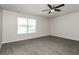 A bedroom with carpeted floors, a ceiling fan, and natural light streaming through a window at 148 Conch Dr, Kissimmee, FL 34759
