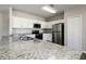 Bright kitchen featuring granite counters, stainless steel appliances, and ample storage space at 148 Conch Dr, Kissimmee, FL 34759