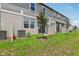 Townhome backyard with green grass, young tree, and an air conditioning unit at 16390 Bird Of Paradise Ave, Clermont, FL 34714