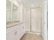 Bright bathroom with granite countertops, dual sinks, and glass enclosed shower at 16390 Bird Of Paradise Ave, Clermont, FL 34714