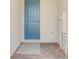 Entrance to a home with a blue front door and brick-laid patio and neutral mat at 16390 Bird Of Paradise Ave, Clermont, FL 34714