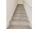 Carpeted stairs with white railings provide a safe and stylish transition between floors at 16390 Bird Of Paradise Ave, Clermont, FL 34714