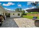 Wide backyard view offering stone patio with seating, playhouse, modern white home exterior and lush lawn with basketball hoop at 2114 Geigel Ct, Orlando, FL 32806