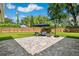 Relaxing backyard area with a stone patio, lounge furniture, a basketball hoop, and lush green landscaping at 2114 Geigel Ct, Orlando, FL 32806