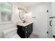 Modern bathroom with white subway tiles, marble countertop, a black vanity, and gold hardware at 2114 Geigel Ct, Orlando, FL 32806
