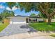 Charming single-story home with a well-manicured lawn and a gray brick driveway offers excellent curb appeal at 2114 Geigel Ct, Orlando, FL 32806