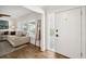 Bright foyer with wood floors leads into a living area featuring a sectional sofa and plantation-shuttered windows at 2114 Geigel Ct, Orlando, FL 32806