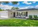 Inviting single-story home with a black front door and rocking chairs adding charm to the brick-paved front porch at 2114 Geigel Ct, Orlando, FL 32806