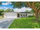 Charming single-story home featuring a brick driveway, a lush green lawn, and rocking chairs on the front porch at 2114 Geigel Ct, Orlando, FL 32806
