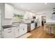 Bright kitchen features white cabinets, black countertops, subway tile, stainless steel appliances, and a farmhouse sink at 2114 Geigel Ct, Orlando, FL 32806