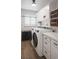 Well-organized laundry room with modern washer and dryer, storage cabinets, shelves, and a window for natural light at 2114 Geigel Ct, Orlando, FL 32806