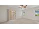 Bedroom with a sliding glass door to a patio, light colored walls, and a ceiling fan at 21144 Royal St Georges Ln, Leesburg, FL 34748