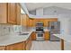 This well-lit kitchen features stainless steel appliances, wood cabinets, and sleek countertops at 21144 Royal St Georges Ln, Leesburg, FL 34748