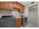 Laundry room with washer, dryer, and sink and oak cabinets above the appliances and the sink at 21144 Royal St Georges Ln, Leesburg, FL 34748