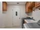 Laundry room with washer, dryer, and sink and oak cabinets above the appliances and the sink at 21144 Royal St Georges Ln, Leesburg, FL 34748