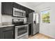 Modern kitchen featuring stainless steel appliances and dark cabinetry at 2280 San Vital Dr # 101, Kissimmee, FL 34741