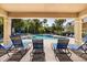 View of the community pool from the shaded cabana, showing lounge chairs and tropical landscaping at 2280 San Vital Dr # 101, Kissimmee, FL 34741