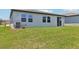 Backyard with green grass, neutral colored house, and modern air conditioning unit at 2365 White Tail St, Davenport, FL 33837