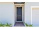 Close-up of the attractive front door, set back in an alcove, with a red brick walk and foundation plants at 2365 White Tail St, Davenport, FL 33837